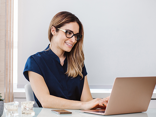 junge-frau-mit-brille-sitzt-am-laptop