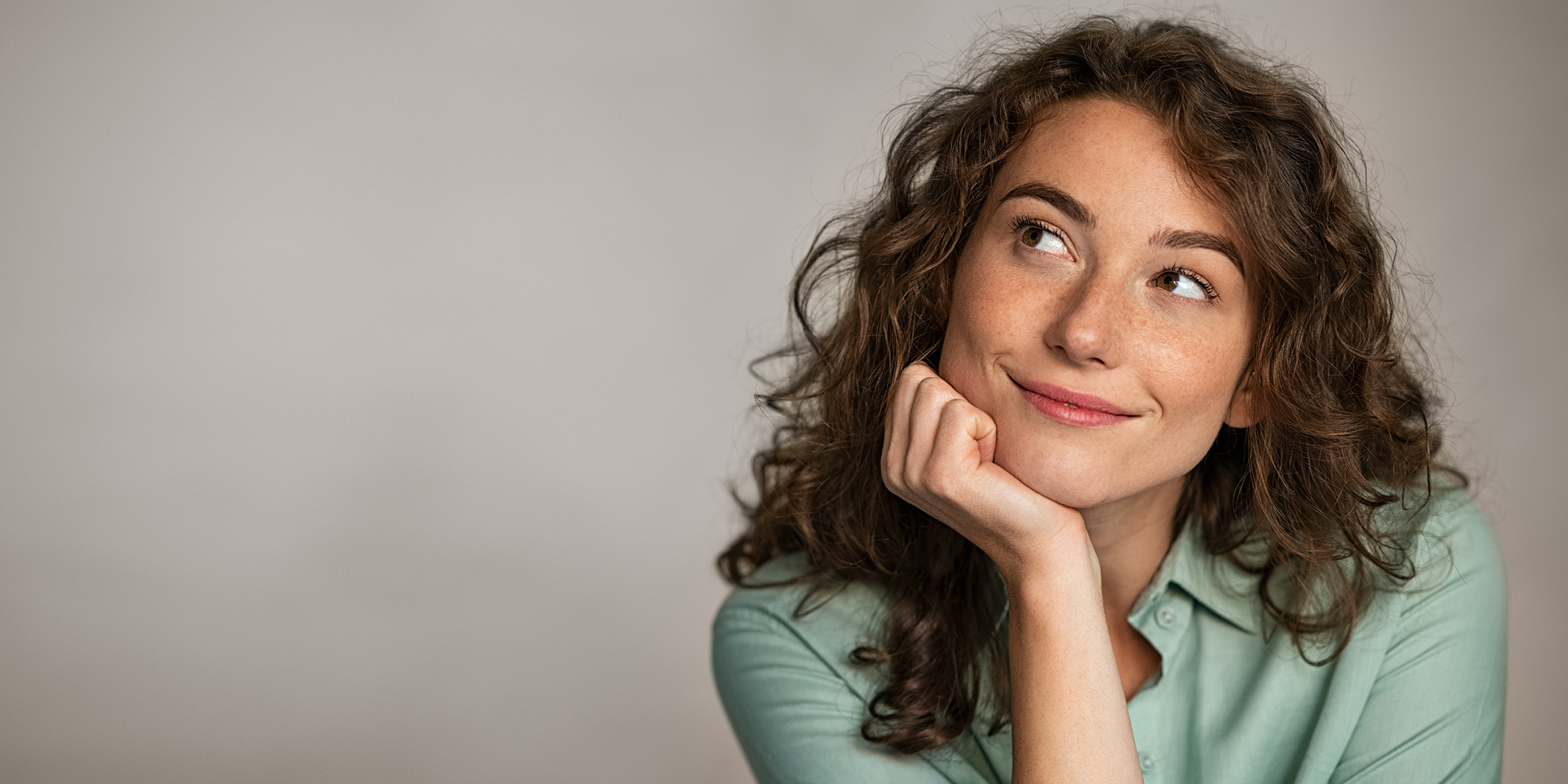 junge-frau-stuetzt-kopf-arm-blick-zur-seite