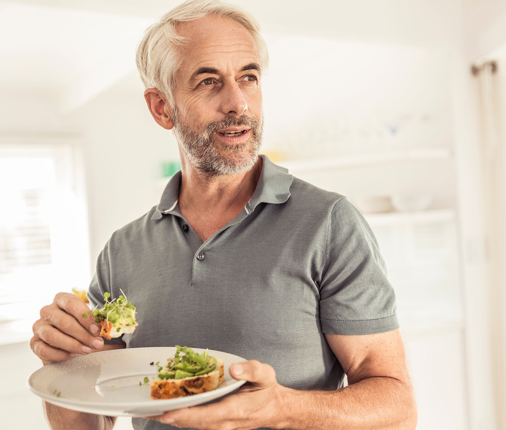 mann-kaut-brot-mit-avocado